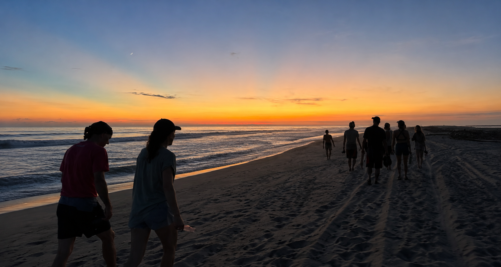 The group walking the beach at sunset